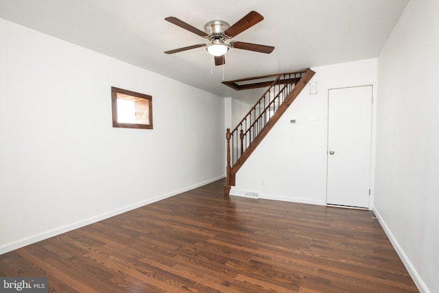 spare room featuring dark wood-style flooring, visible vents, stairway, and baseboards