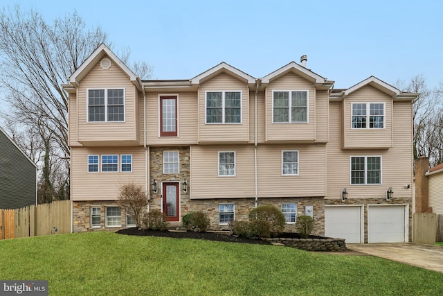 view of front of property featuring driveway, a front lawn, stone siding, and fence