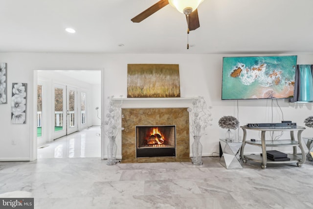 living room with a ceiling fan, recessed lighting, marble finish floor, and a fireplace