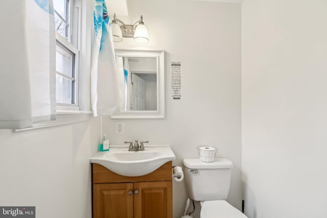 half bath featuring toilet and vanity