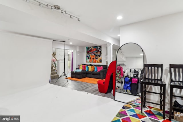 bedroom with wood finished floors, track lighting, and recessed lighting