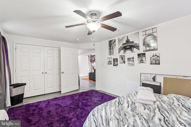 bedroom featuring baseboards, a closet, a ceiling fan, and wood finished floors