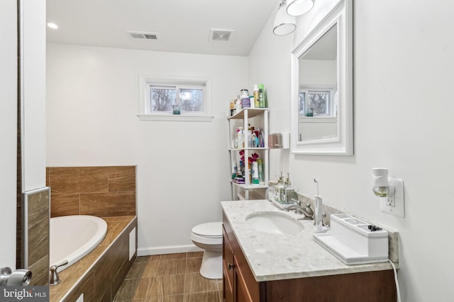 bathroom with visible vents, vanity, baseboards, and a bath