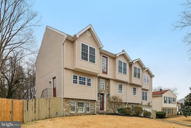 multi unit property with stone siding and fence