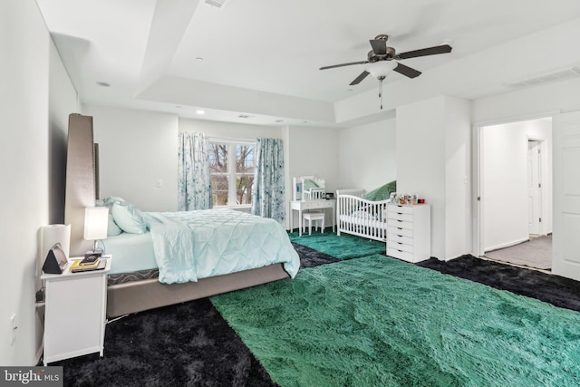 carpeted bedroom with a ceiling fan and visible vents