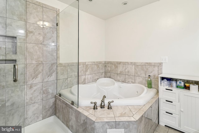 bathroom with a tub with jets, a shower stall, and tile patterned floors