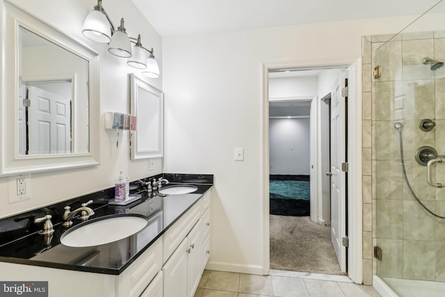 full bathroom featuring double vanity, tile patterned flooring, a shower stall, and a sink