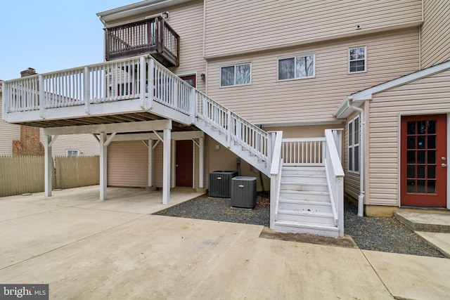 exterior space with a deck, stairway, cooling unit, and fence