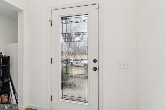 doorway to outside with baseboards