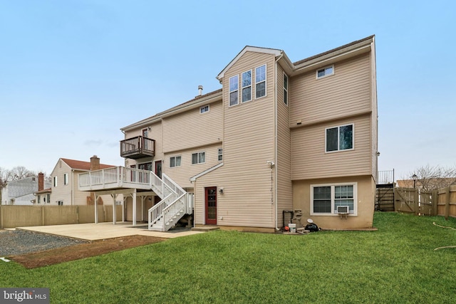 rear view of house featuring a yard, a fenced backyard, a patio, and stairs