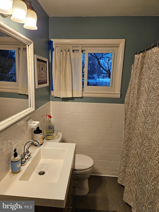 full bath featuring toilet, a wainscoted wall, vanity, tile walls, and a shower with curtain