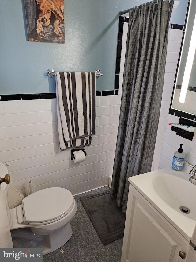 bathroom with toilet, curtained shower, and tile walls