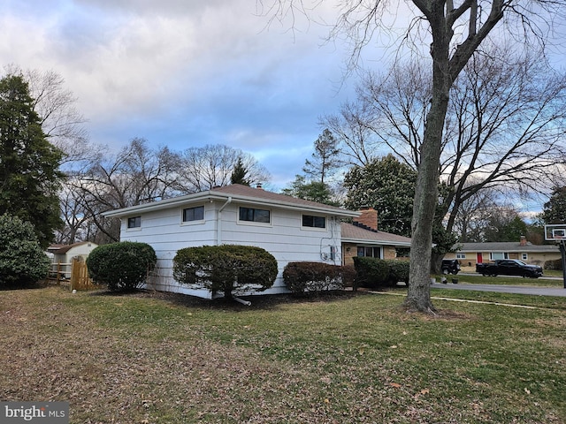 view of front facade featuring a chimney and a front lawn