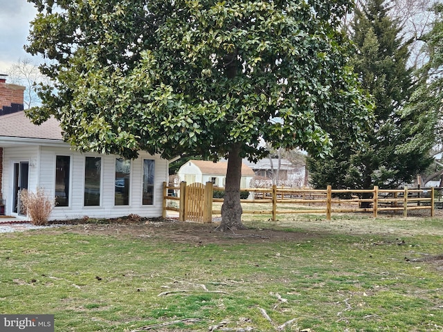 exterior space featuring a lawn, fence, and a gate