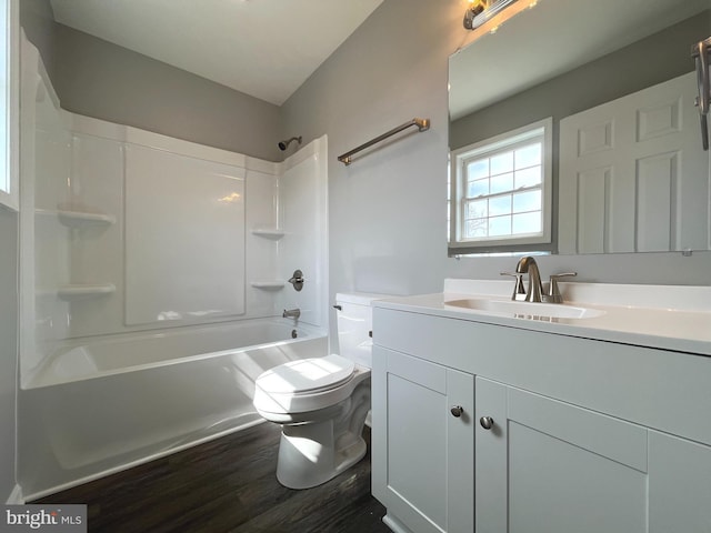 full bath with toilet,  shower combination, wood finished floors, and vanity