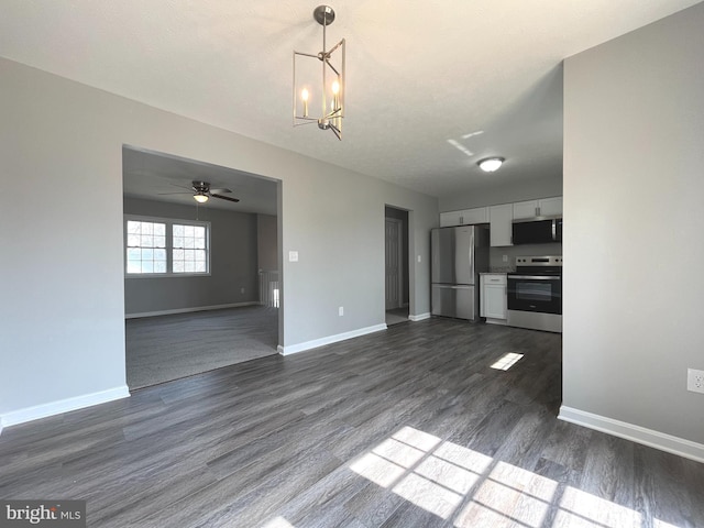 unfurnished living room with baseboards, dark wood-type flooring, and ceiling fan with notable chandelier