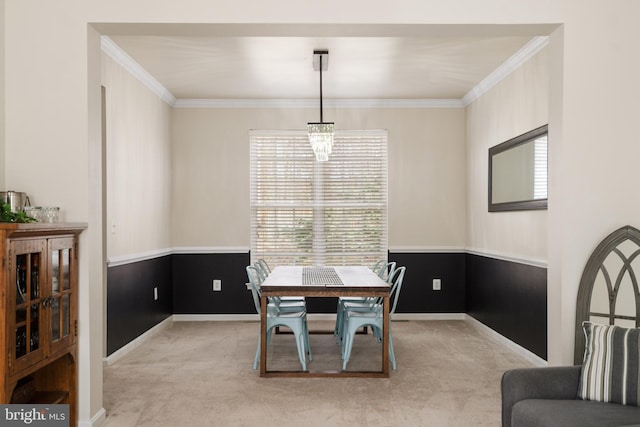 carpeted dining room with baseboards, wainscoting, and ornamental molding