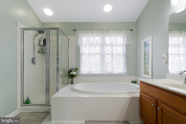 full bathroom with a shower stall, vanity, and a garden tub