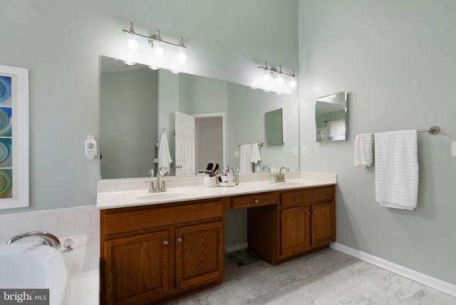 bathroom with baseboards, double vanity, a sink, a garden tub, and marble finish floor