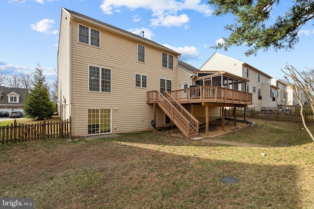 rear view of house featuring a lawn, a fenced backyard, stairway, a sunroom, and a wooden deck