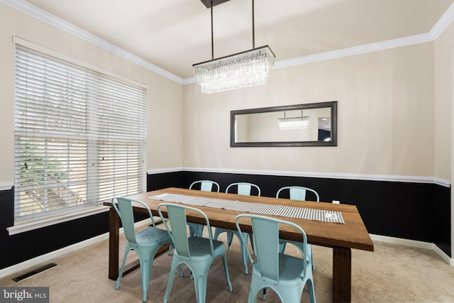 dining room featuring crown molding, carpet, visible vents, and baseboards