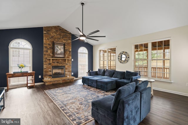 living room featuring lofted ceiling, wood finished floors, a fireplace, and a wealth of natural light