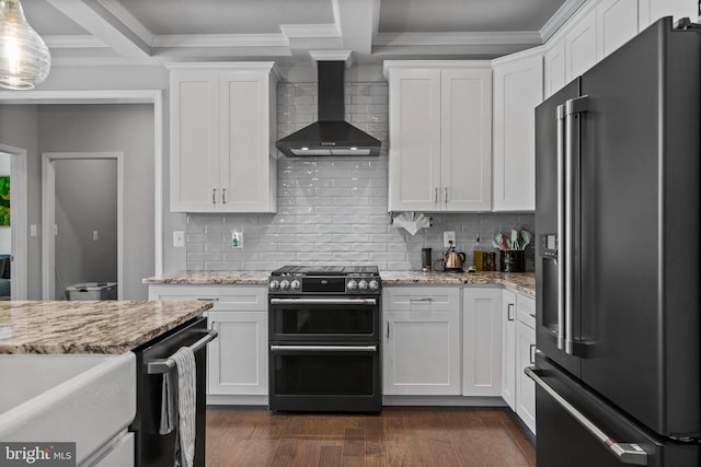 kitchen featuring dark wood-type flooring, high end refrigerator, white cabinets, wall chimney range hood, and double oven range