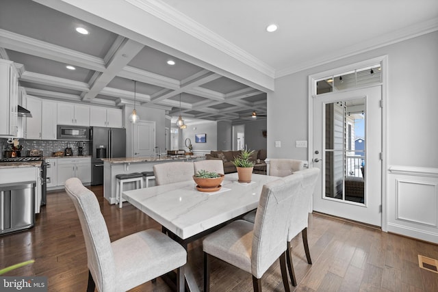 dining room featuring dark wood-style flooring, ornamental molding, beamed ceiling, and coffered ceiling