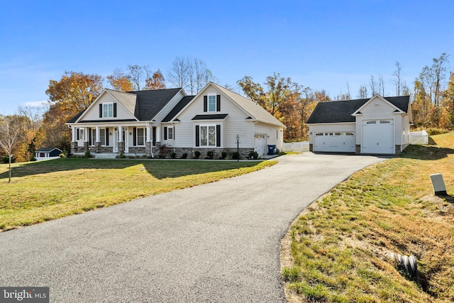 view of front of home featuring covered porch, stone siding, a front yard, and a garage