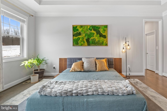 bedroom with ornamental molding, wood finished floors, and baseboards