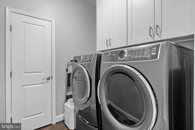 clothes washing area with dark wood-style floors, cabinet space, and washer and dryer