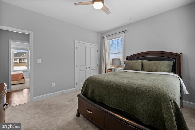 bedroom with ceiling fan, a closet, carpet flooring, and baseboards