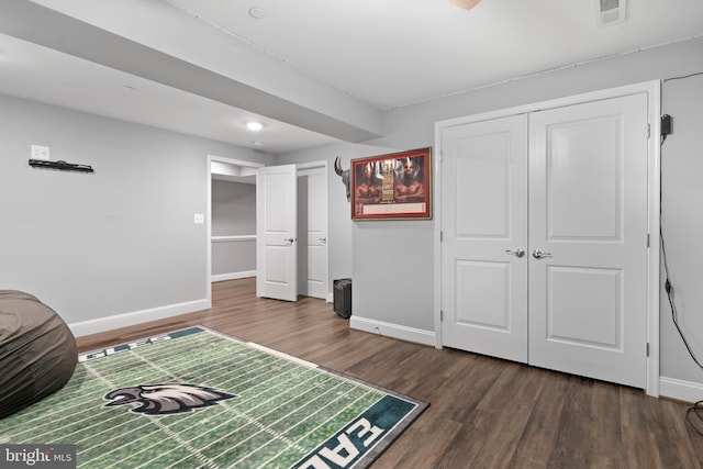 bedroom featuring a closet, visible vents, baseboards, and wood finished floors