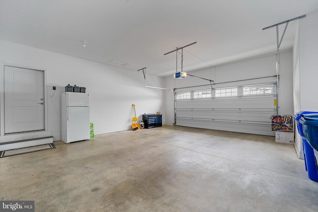 garage featuring a garage door opener and freestanding refrigerator