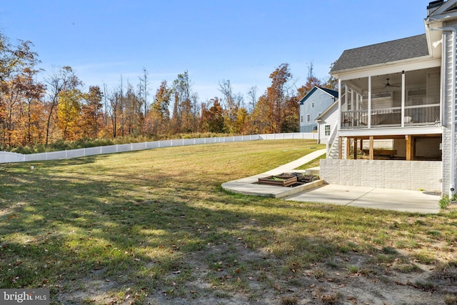 view of yard with a patio, a sunroom, ceiling fan, fence, and stairs