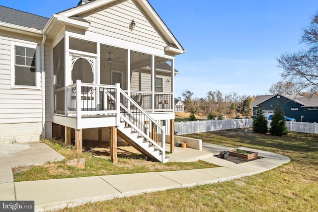 view of front of property with a front yard, a sunroom, fence, and stairs