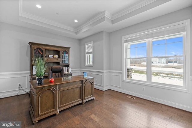 office space with a tray ceiling, dark wood-style flooring, a wealth of natural light, and ornamental molding