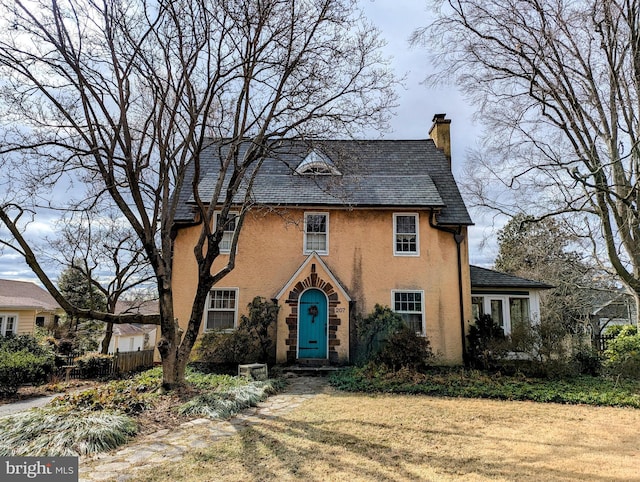 view of front of home with a chimney, fence, and a front yard