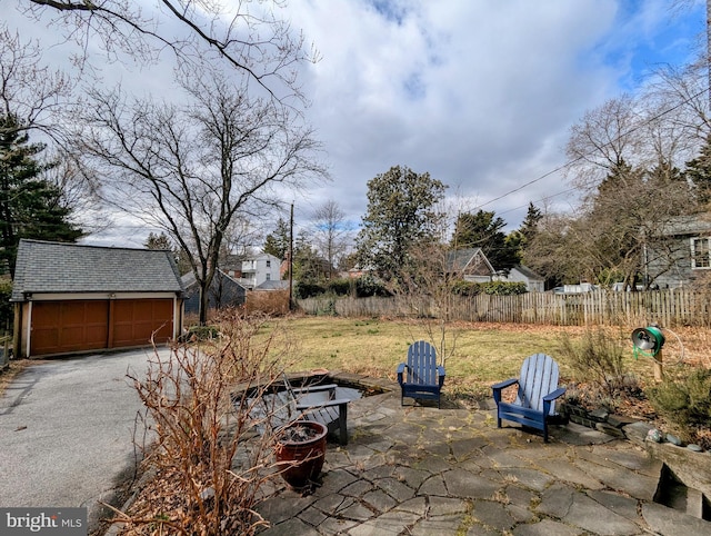 view of patio / terrace featuring a garage, fence, and an outdoor structure