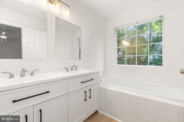 6185 Newton Ln, Bealeton, VA 22712 - bathroom featuring double vanity, a garden tub, a ceiling fan, and wood finished floors