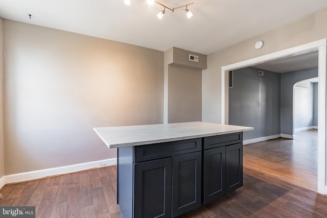 305 Drew St, Baltimore, MD 21224 - kitchen featuring arched walkways, light countertops, dark wood finished floors, and baseboards