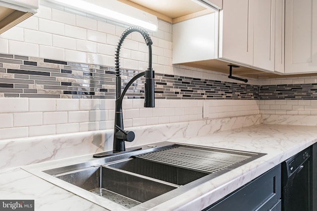 305 Drew St, Baltimore, MD 21224 - interior details with light stone counters, black dishwasher, a sink, and backsplash