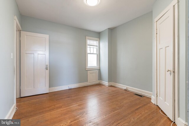 305 Drew St, Baltimore, MD 21224 - unfurnished bedroom with light wood finished floors, baseboards, and visible vents