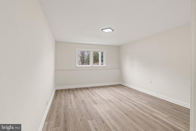 spare room with light wood-style flooring and baseboards