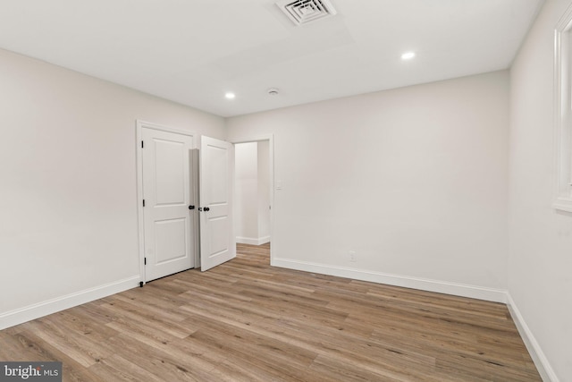 unfurnished room featuring light wood-style flooring, recessed lighting, visible vents, and baseboards