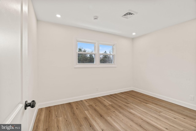 spare room with light wood-type flooring, visible vents, baseboards, and recessed lighting