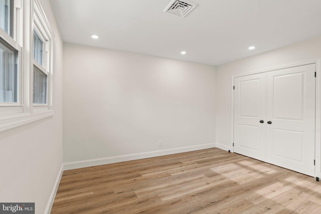 spare room with recessed lighting, light wood-type flooring, visible vents, and baseboards