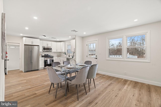 dining space with recessed lighting, light wood-style flooring, and baseboards