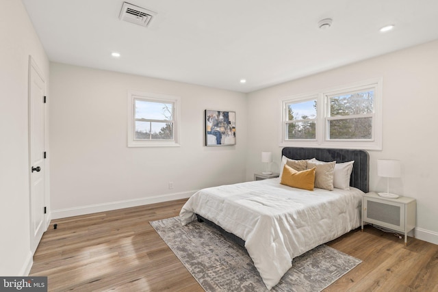 bedroom featuring recessed lighting, light wood-type flooring, visible vents, and baseboards