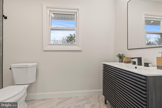 bathroom featuring marble finish floor, toilet, and baseboards